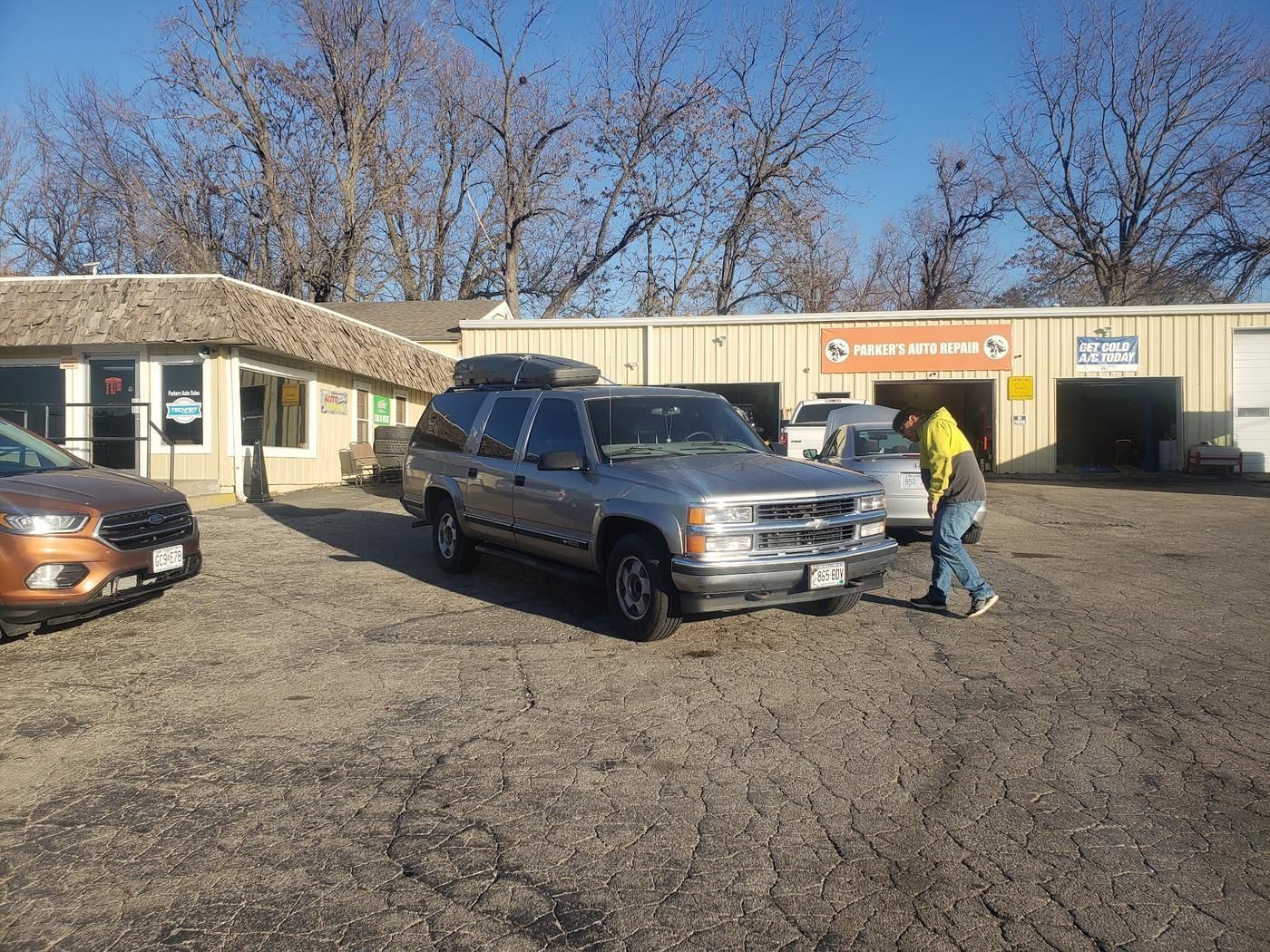 The Parker's Auto Repair lot with customer vehicles outside the office and garage